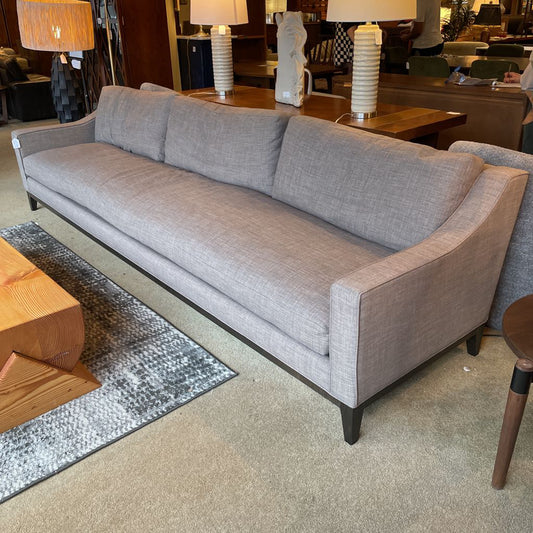 Gray sofa in a room with wooden furniture and decor
