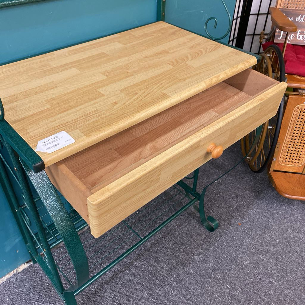 Wooden folding table with a drawer on wheels in an indoor setting