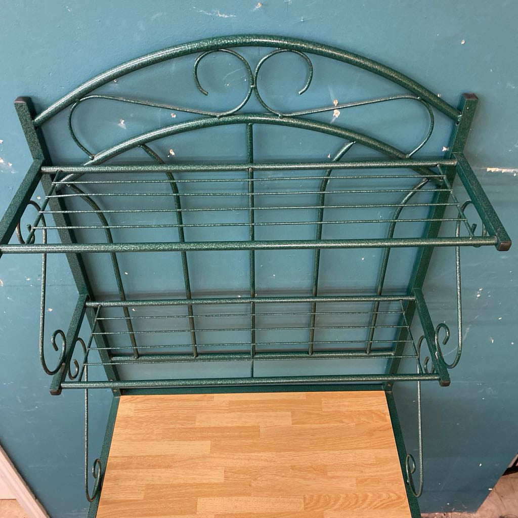 Green metal shelf against a blue wall