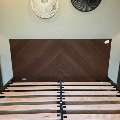 Wooden door with a chevron pattern and a staircase with wooden steps.