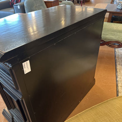 Stack of black furniture pieces on a wooden floor