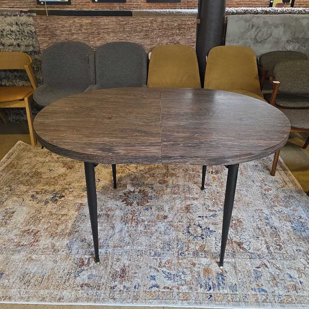 Wooden dining table with metal legs on a patterned rug