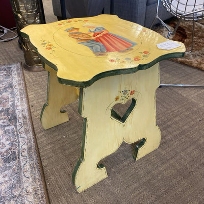 Decorative stool with painted design on a carpeted floor