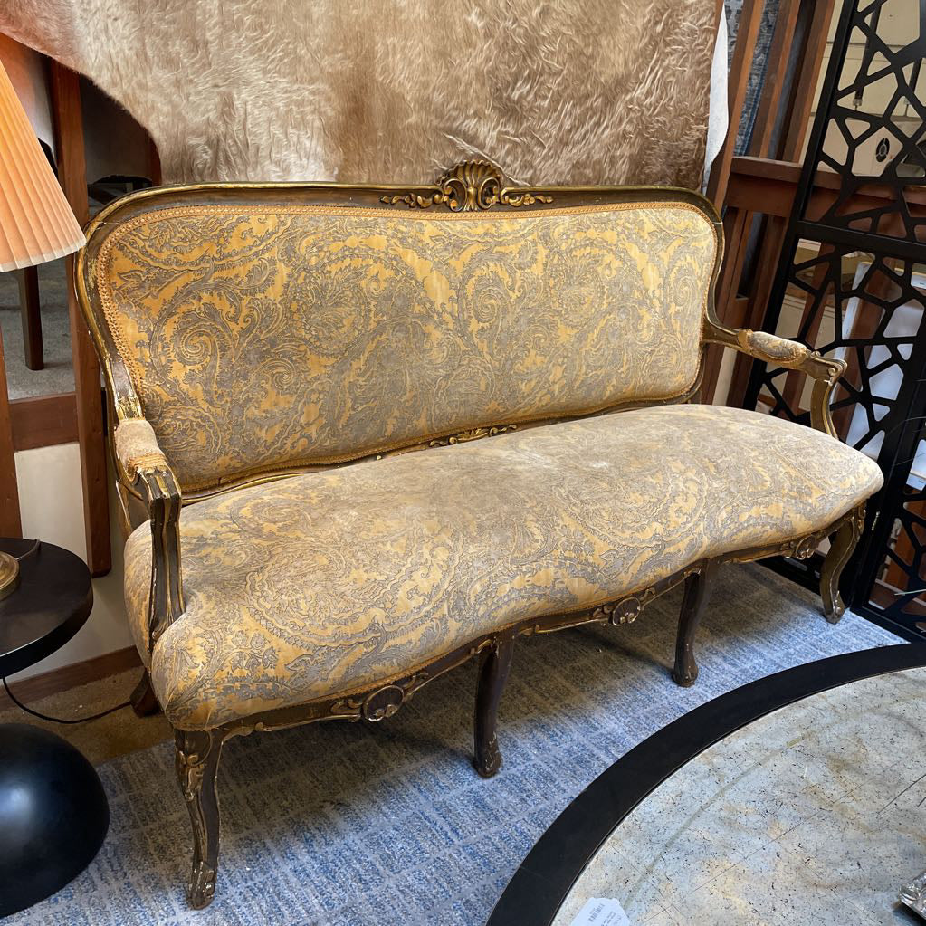 Vintage-style sofa with intricate gold patterns in a room setting