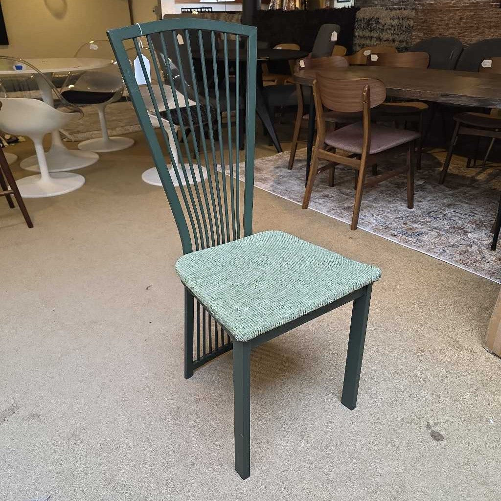 Green chair with a textured seat in a room with tables and chairs.