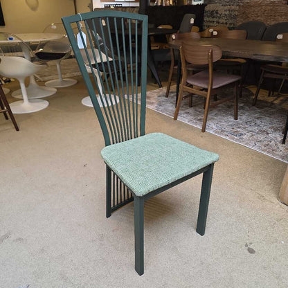 Green chair with a textured seat in a room with tables and chairs.