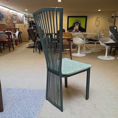Chair with green cushion in a room with other chairs and tables