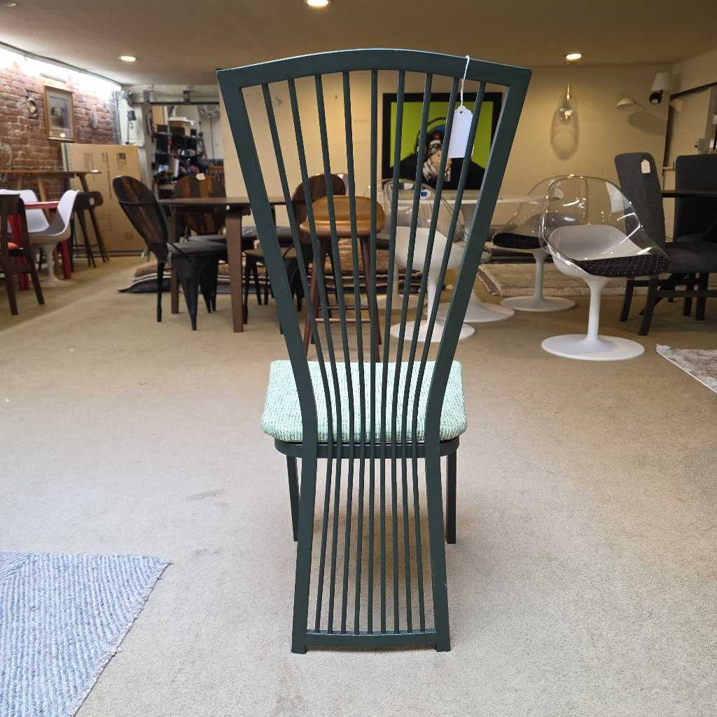 Green metal chair with a textured cushion in a showroom setting