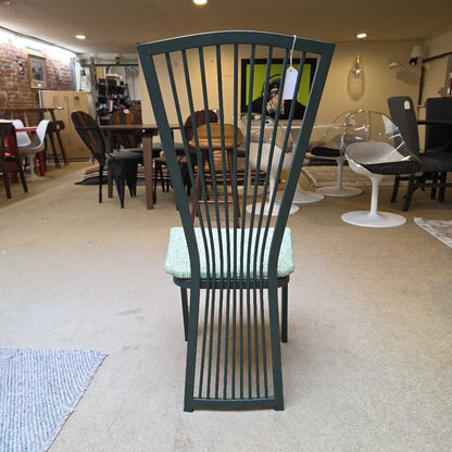 Green metal chair with a textured cushion in a showroom setting