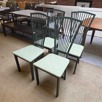 Green metal chairs with cushioned seats on a beige floor.