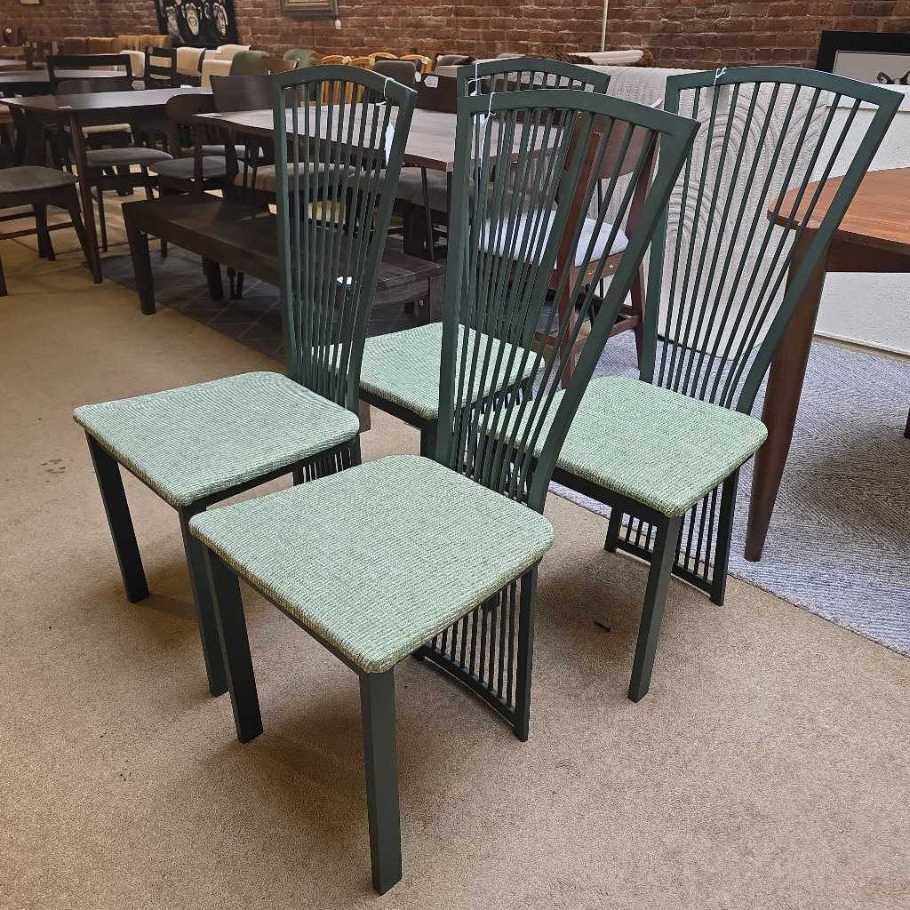 Green chairs with woven seats and backs in a room with tables and chairs.