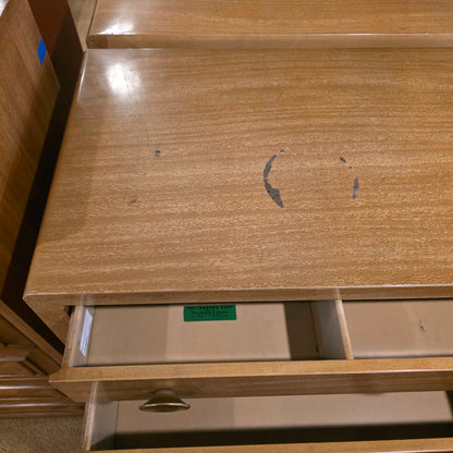 Wooden wardrobe with a smiley face drawn on it, showing signs of wear.