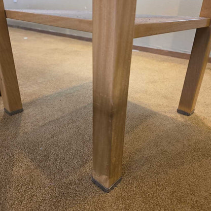 Close-up of a wooden chair leg on a carpeted floor