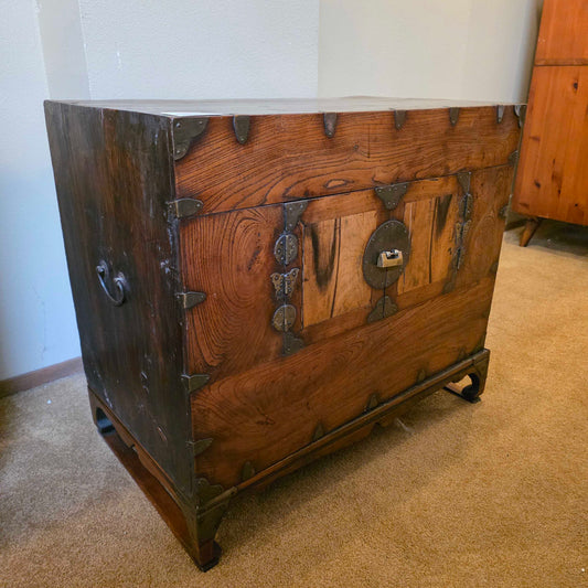 Wooden chest with metal locks on a carpeted floor