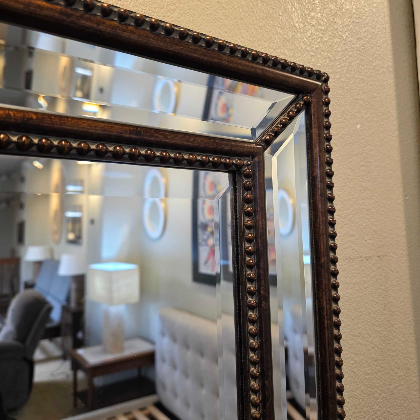 Decorative mirror with a brown frame on a wall