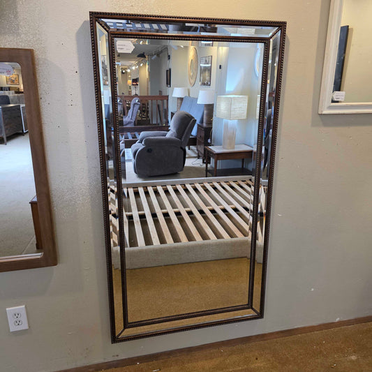 Large rectangular mirror with decorative frame on a wall