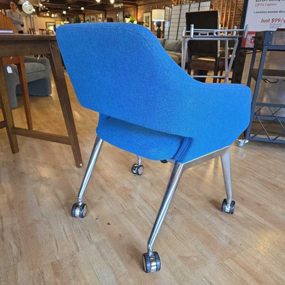Blue office chair with wheels on a wooden floor in a store setting