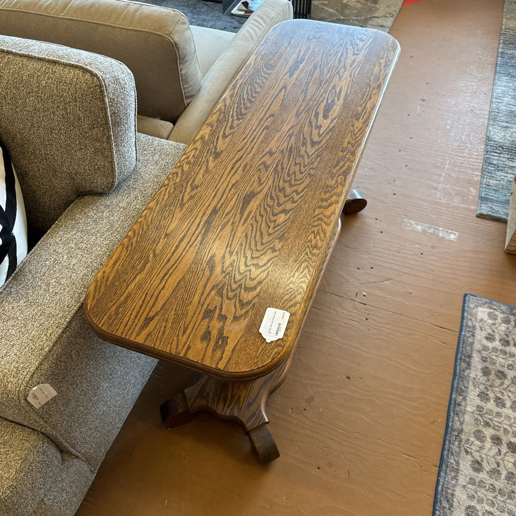 Wooden coffee table next to a beige sofa on a wooden floor.