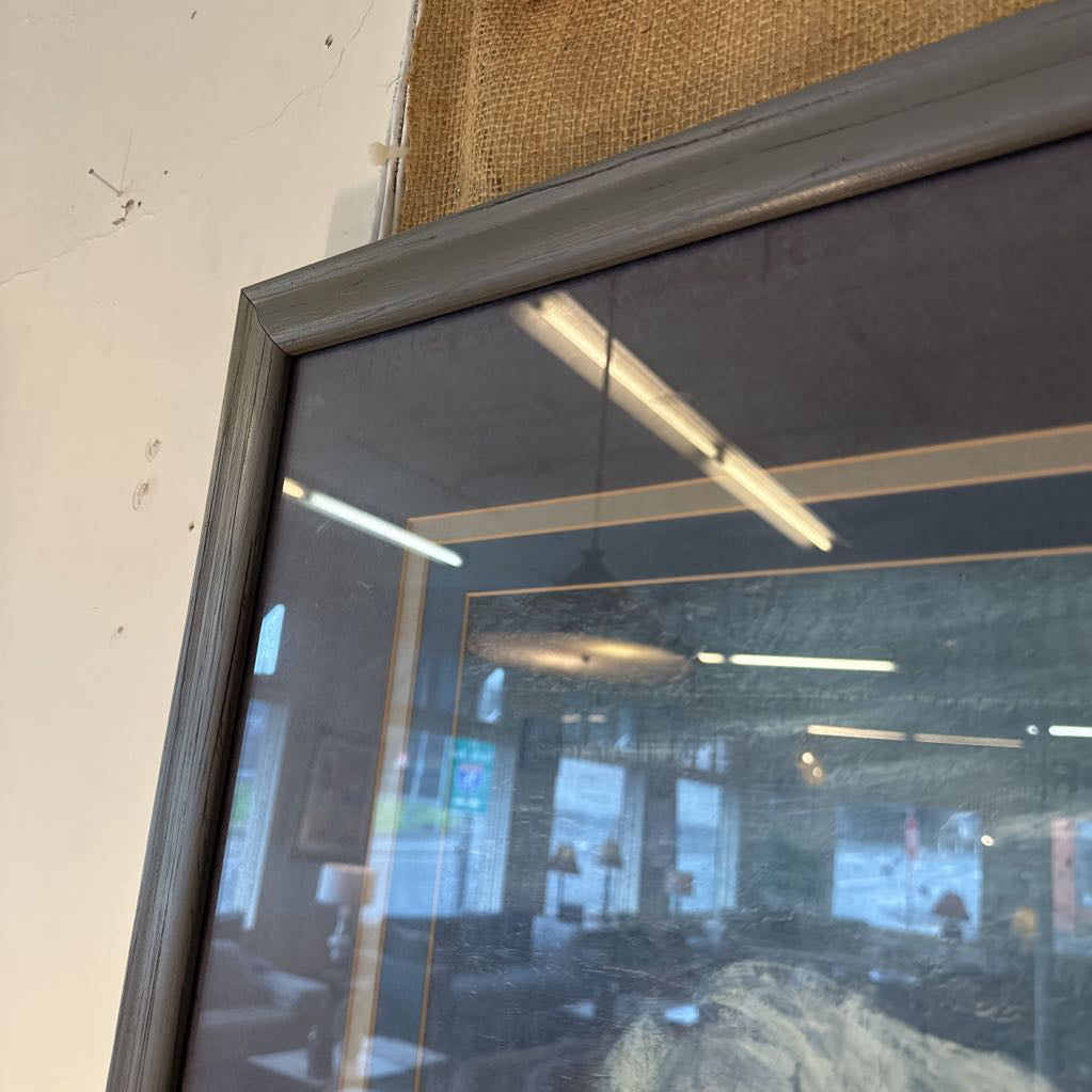 Close-up of a glass door with a metal frame, reflecting interior elements.