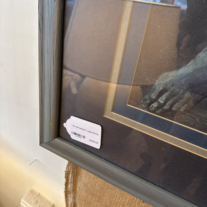 Framed artwork with a label on a white wall