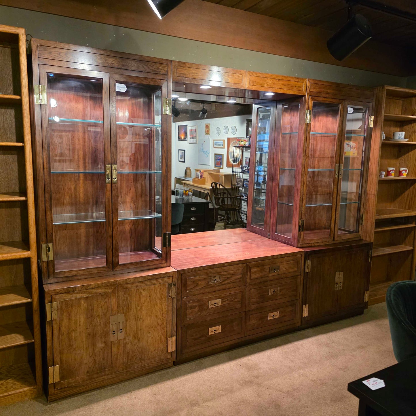 Wooden display case with glass panels on a beige wall.