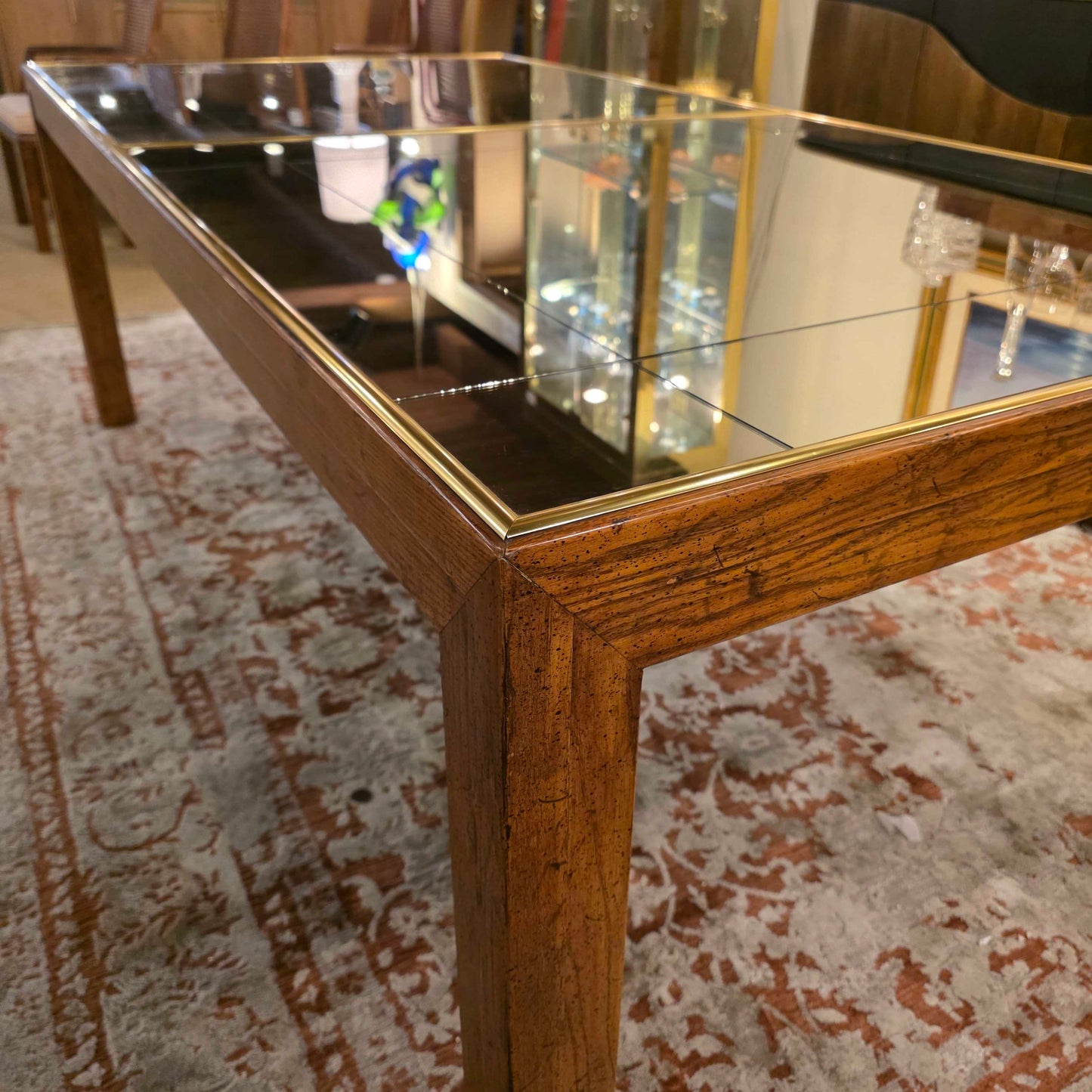 Close-up of a mirror with a wooden frame on a textured wall.