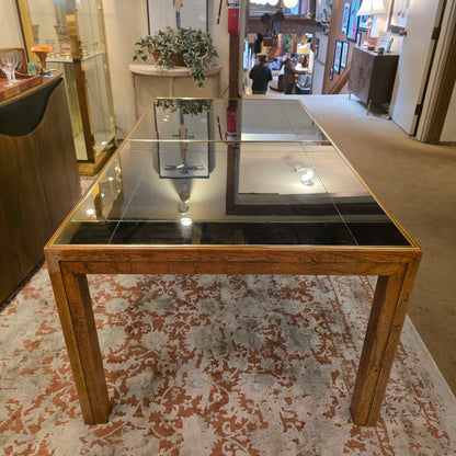 Modern kitchen island with wooden frame and glass panels, featuring a patterned wall in the background.