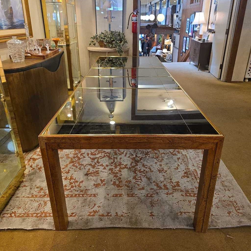 Glass-top dining table with wooden frame in a room setting