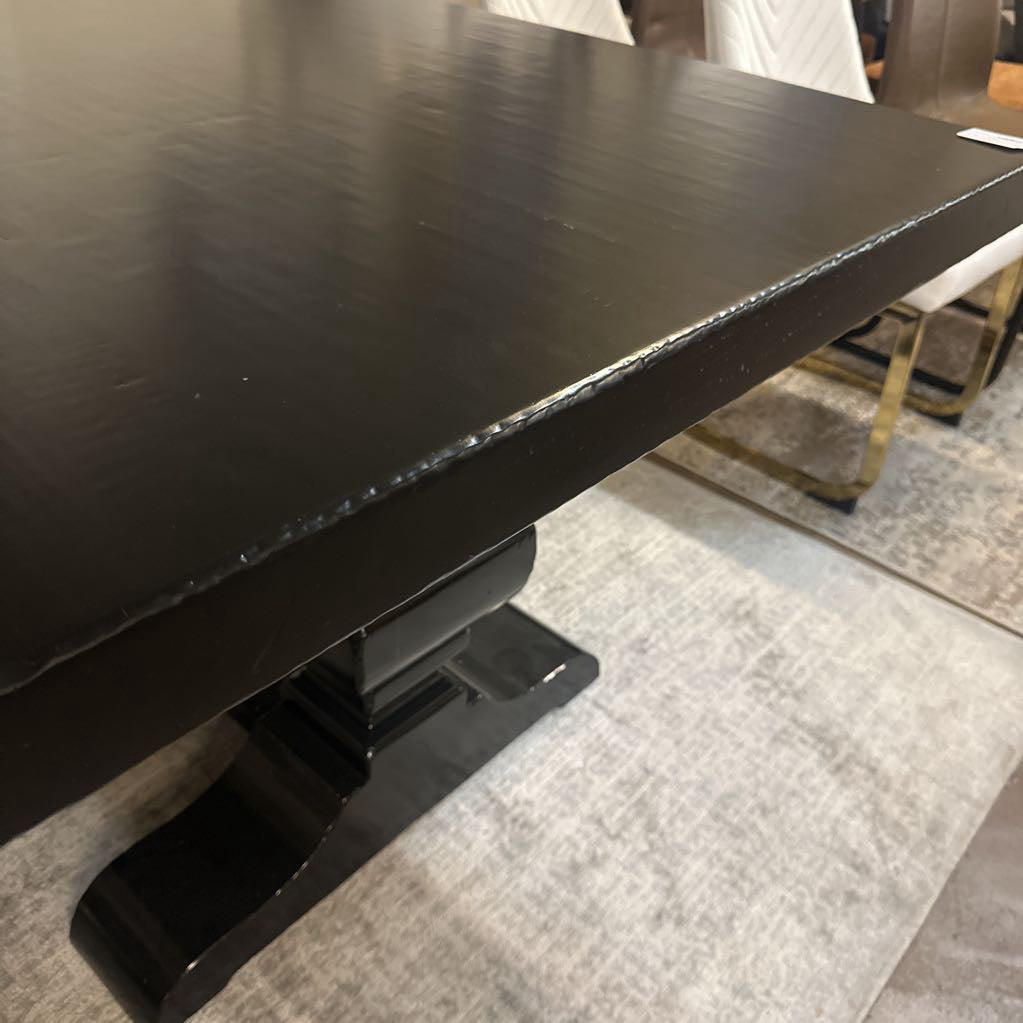 Black table with a textured surface on a gray carpeted floor