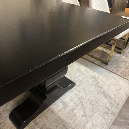 Black table with a textured surface on a gray carpeted floor