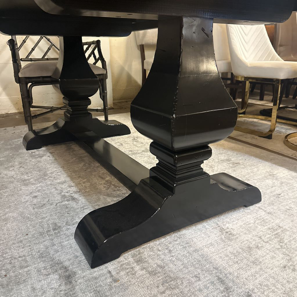 Close-up of a black wooden table leg on a textured surface