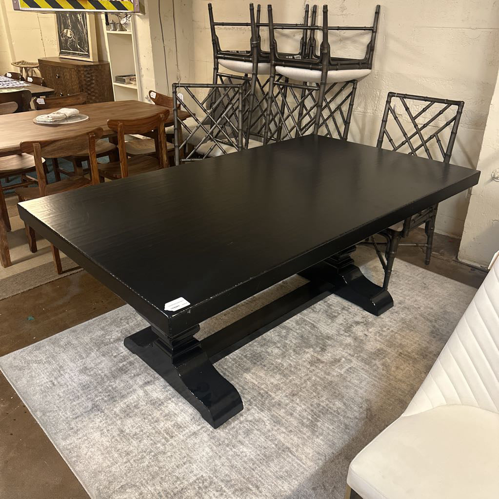 Black dining table with chairs in a showroom setting