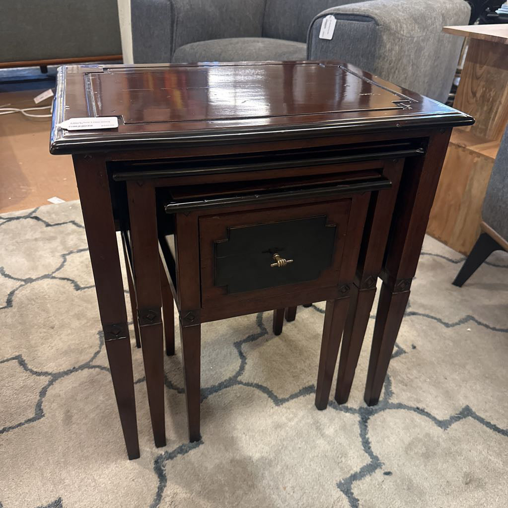 Set of three nested wooden tables on a patterned carpet