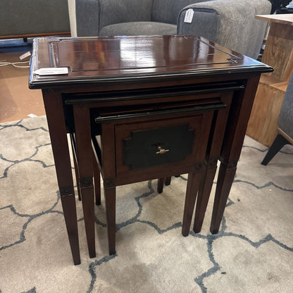 Set of three nested wooden tables on a patterned carpet