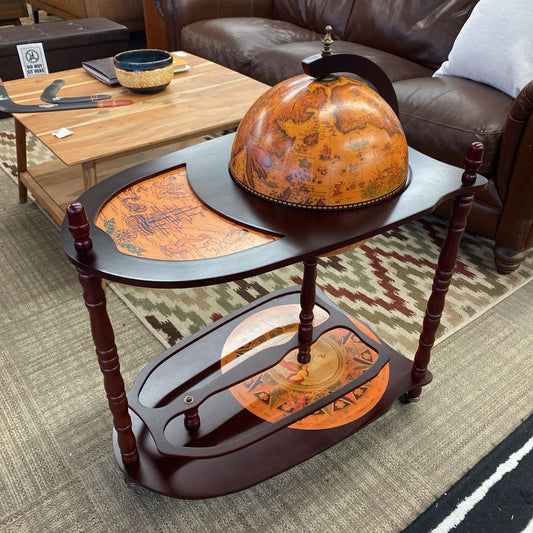 Decorative table with a vintage-style globe design in a living room setting.