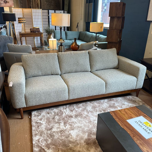 Gray sofa in a living room setting with decor elements.