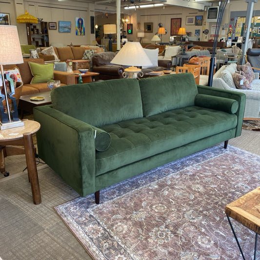 Green sofa in a room with furniture and decor