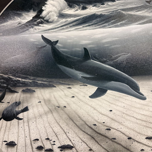 Two dolphins swimming near a rocky coastline with waves.