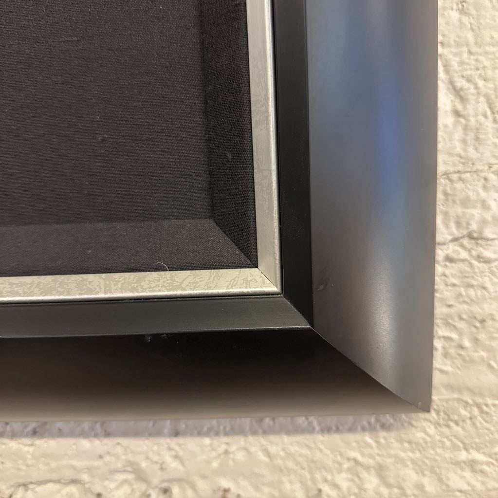Close-up of a black picture frame corner on a textured surface