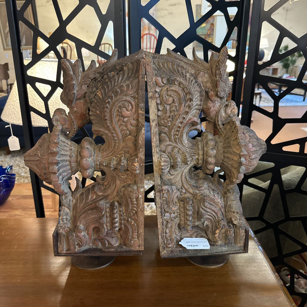 Decorative wooden panels with intricate carvings on a table.