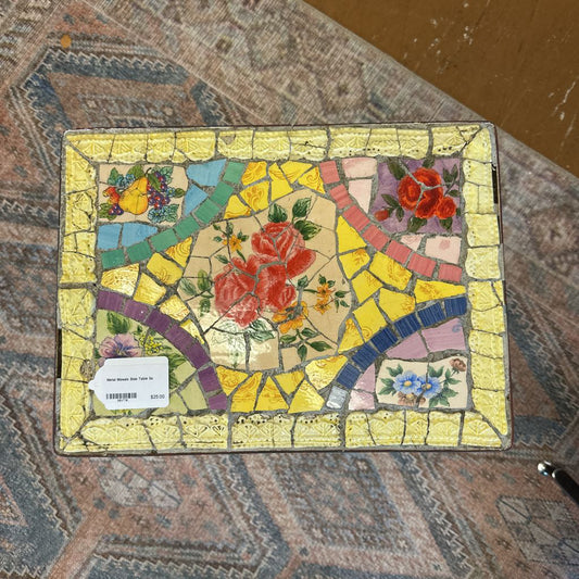 Mosaic artwork with floral designs on a textured surface