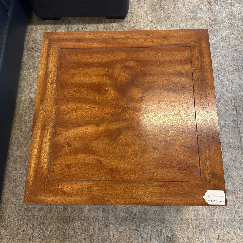 Wooden square table on a gray carpeted floor