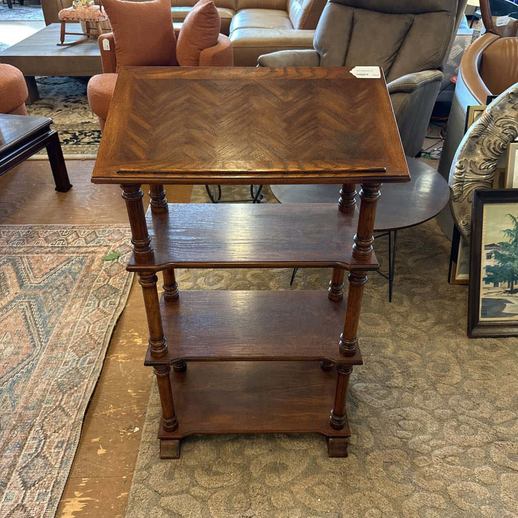 Wooden side table with three shelves in a living room setting