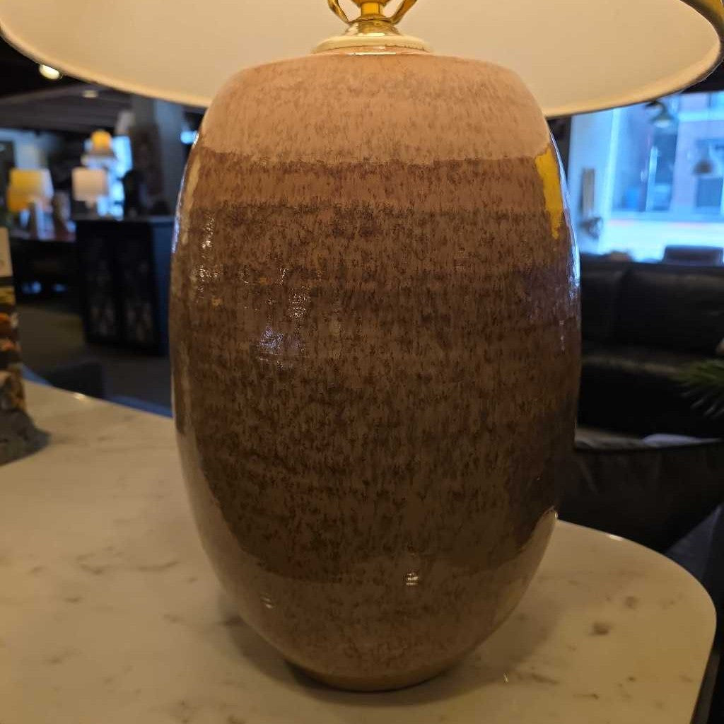 Brown textured vase on a marble surface with a blurred indoor background