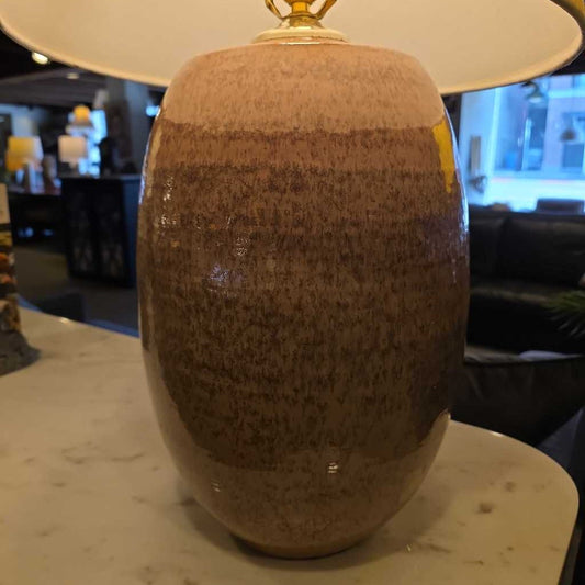 Brown textured vase on a marble surface with a blurred indoor background