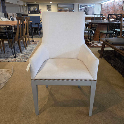 White upholstered chair with a blurred background of a store interior.