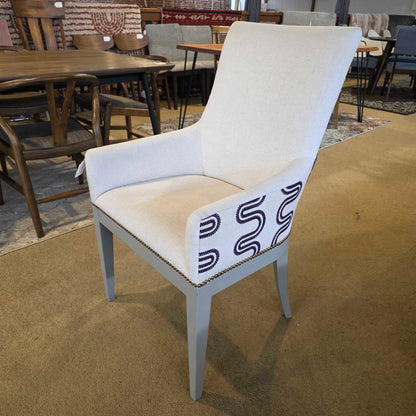 White chair with a patterned cushion on a beige carpet