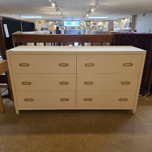 Beige storage cabinet with gold handles in a room setting