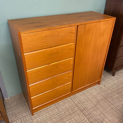 Wooden dresser with multiple drawers against a plain wall.