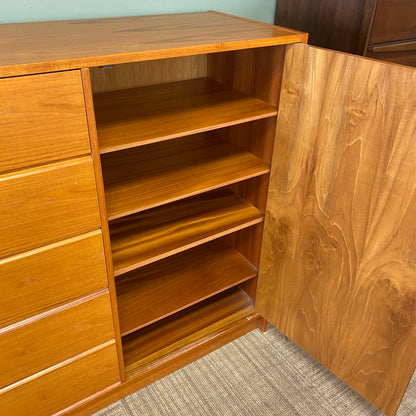 Wooden cabinet with multiple drawers and shelves on a carpeted floor.